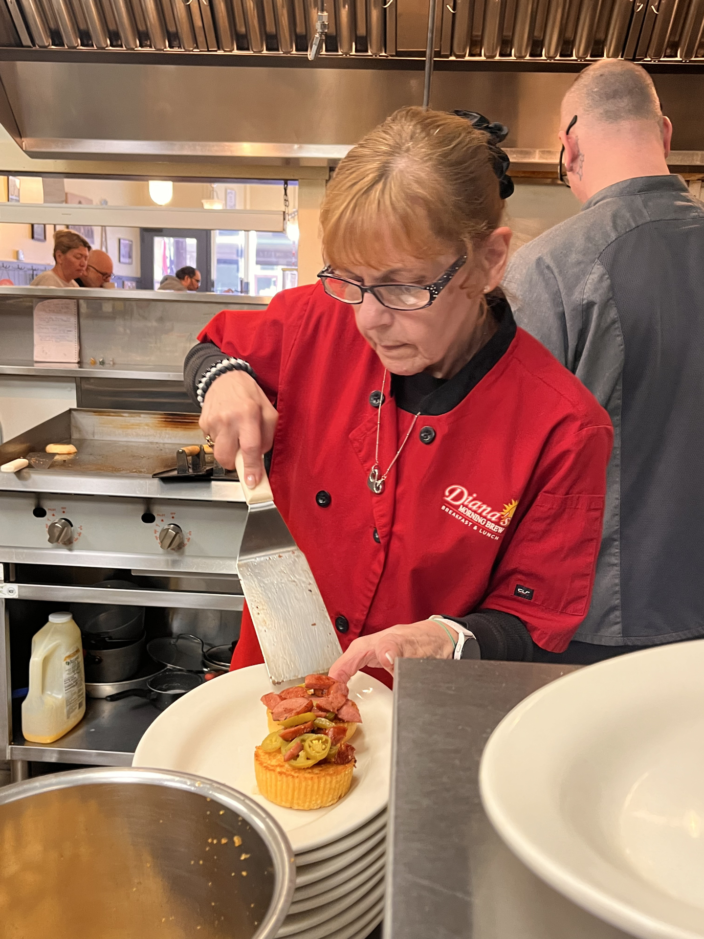 Diana plating a dish in the kitchen